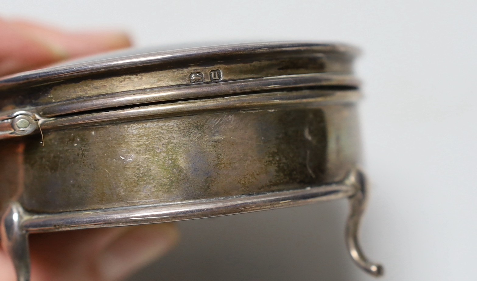 A George V silver mounted tortoiseshell circular trinket box, Horton & Allday, Birmingham 1919, 81mm, together with a pair of mid 18th century silver sugar nips.